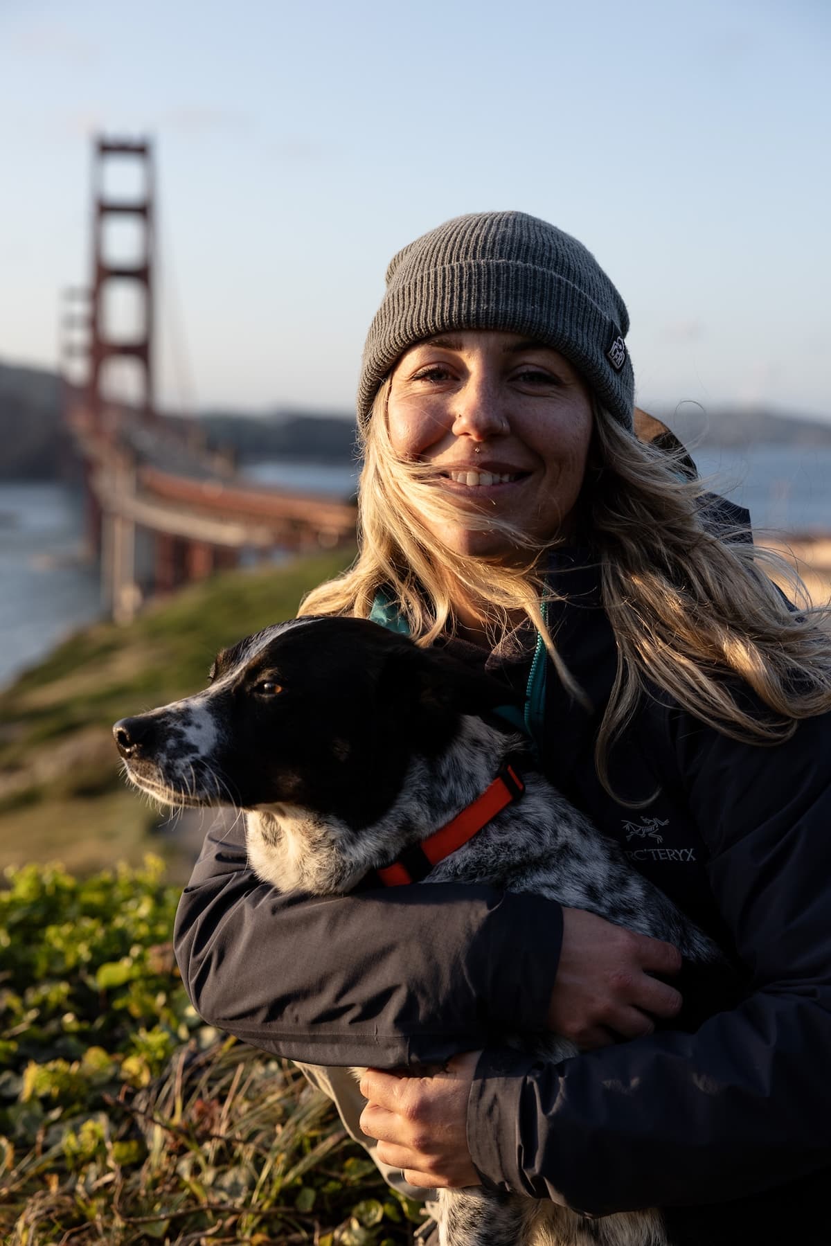Kaiya smiling and holding her dog,
Blueberry, near the Golden Gate Bridge